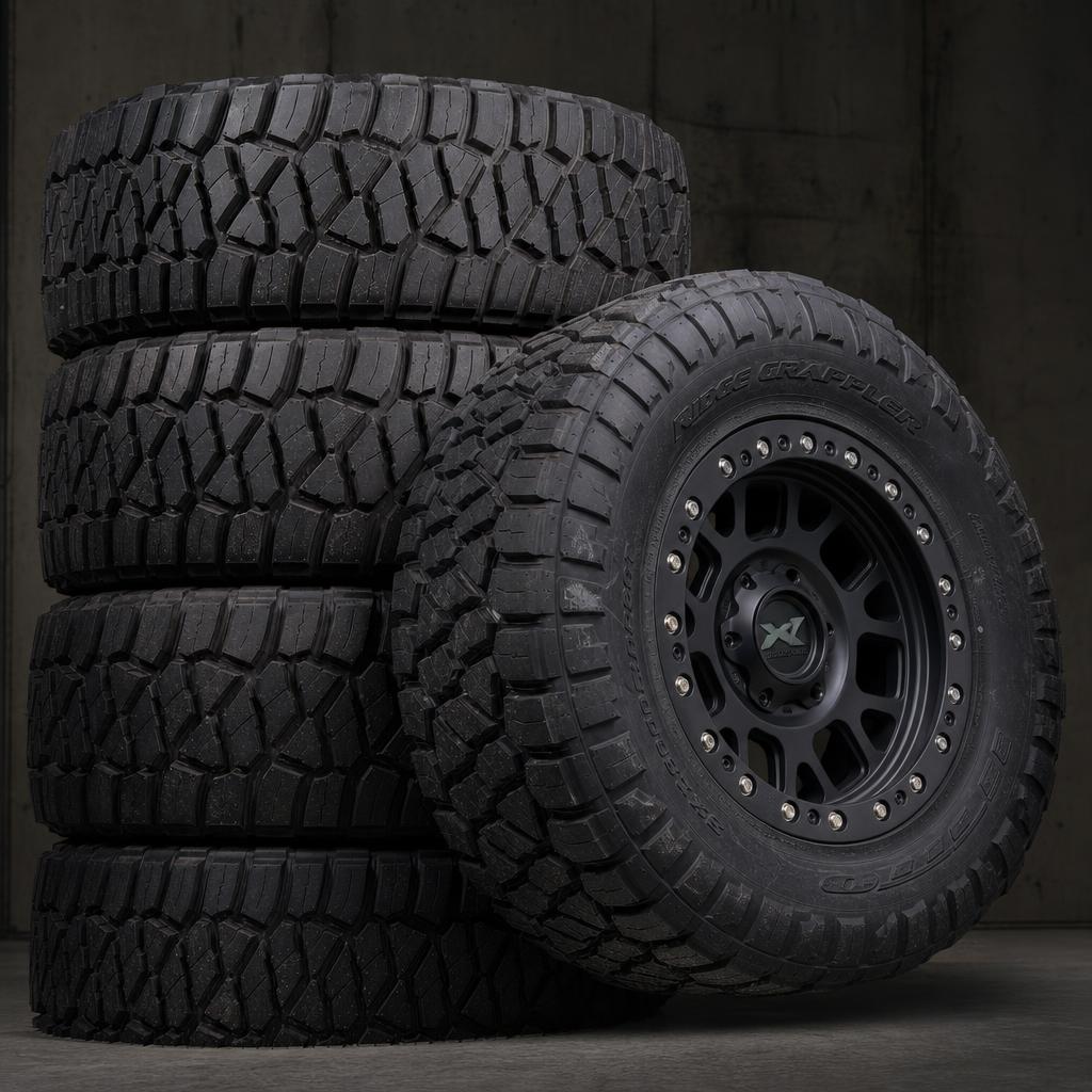Close up of an off-road wheel and mud terrain tire covered in dust
